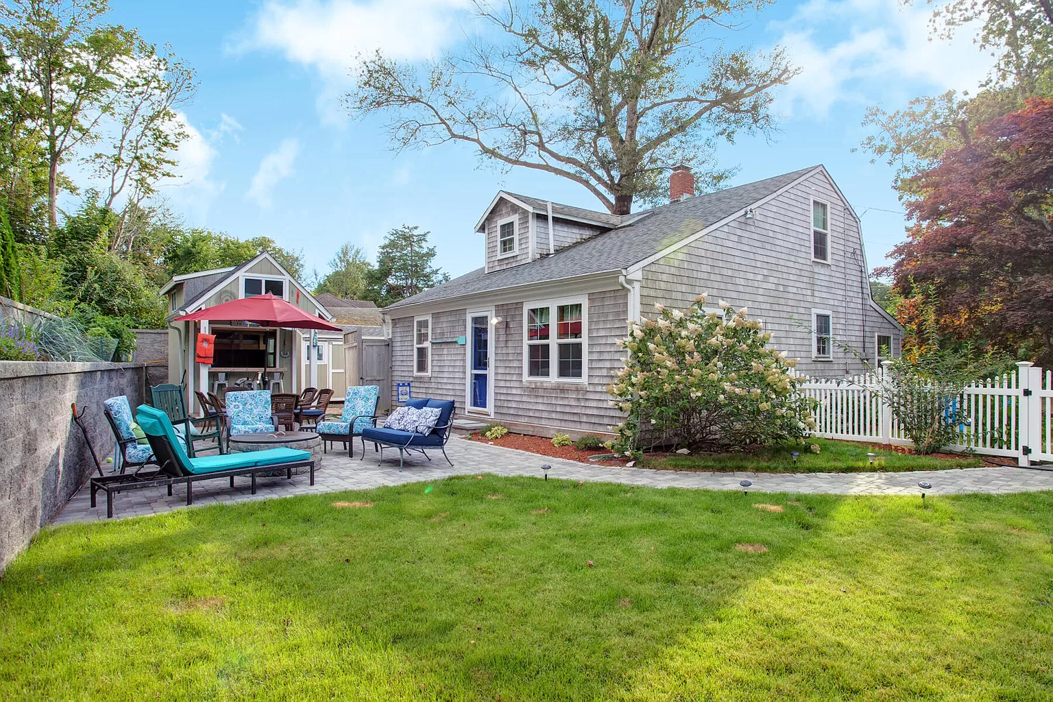 The back of Olde Millie with the lawn and patio area in afternoon light.